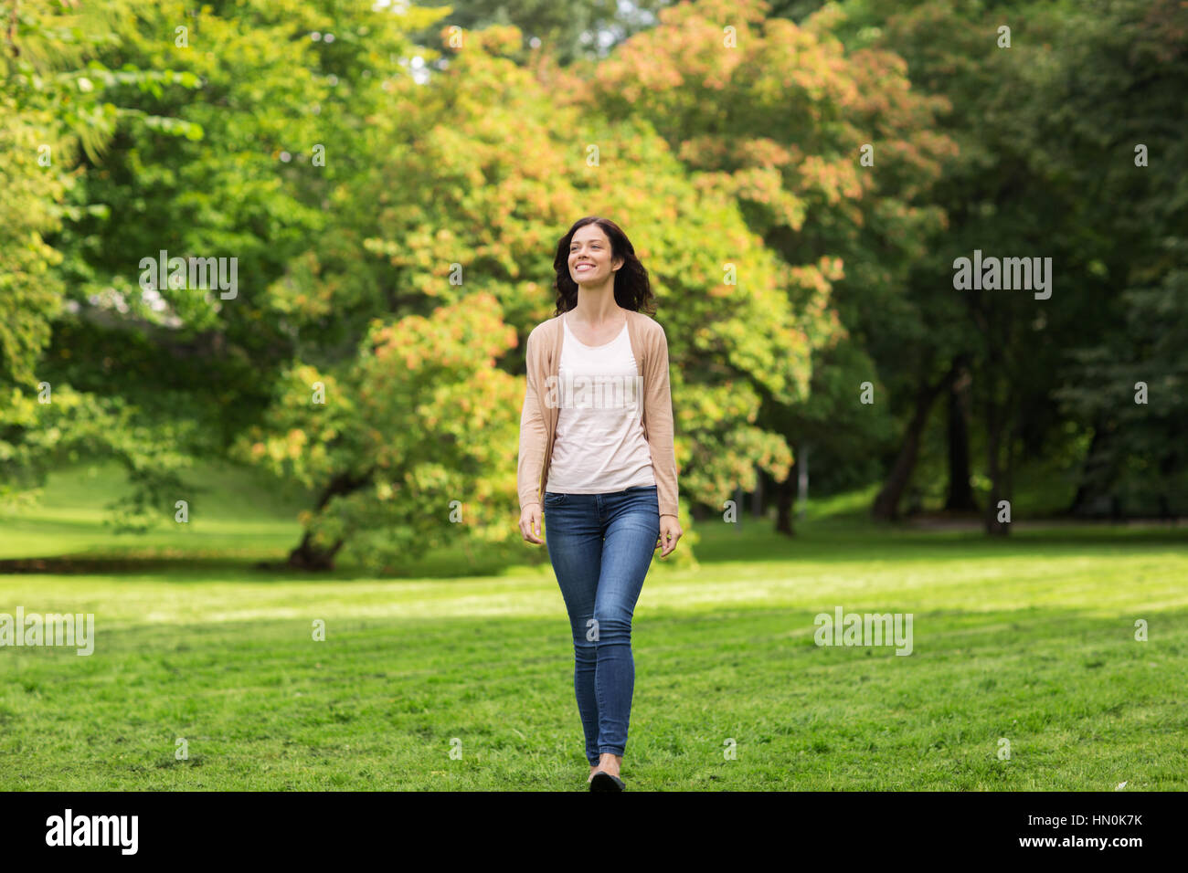 beautiful happy young woman walking in summer park Stock Photo - Alamy