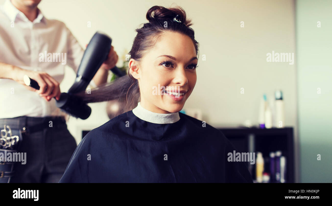 Happy Woman With Stylist Making Hairdo At Salon Stock Photo