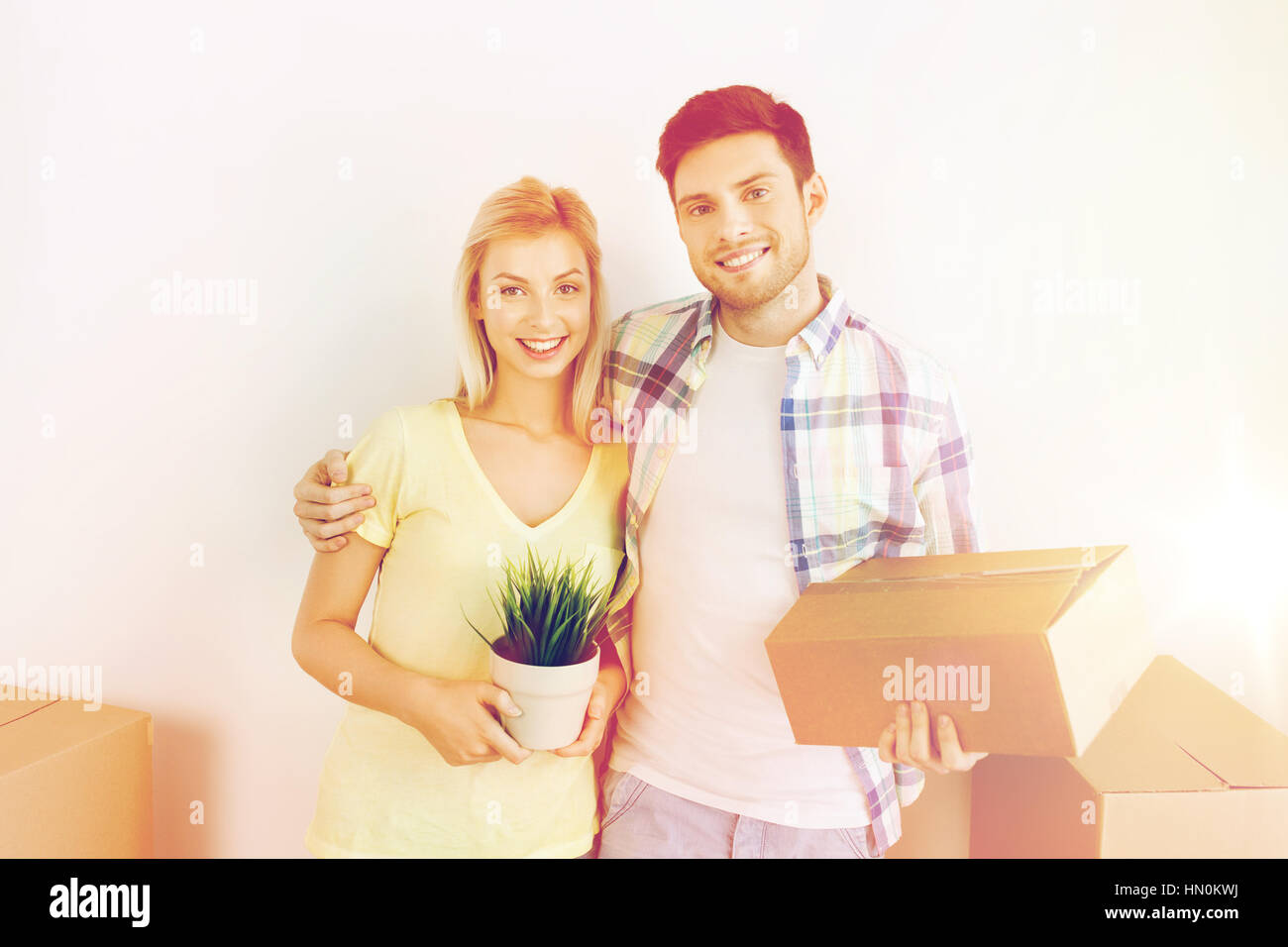 smiling couple with big boxes moving to new home Stock Photo - Alamy