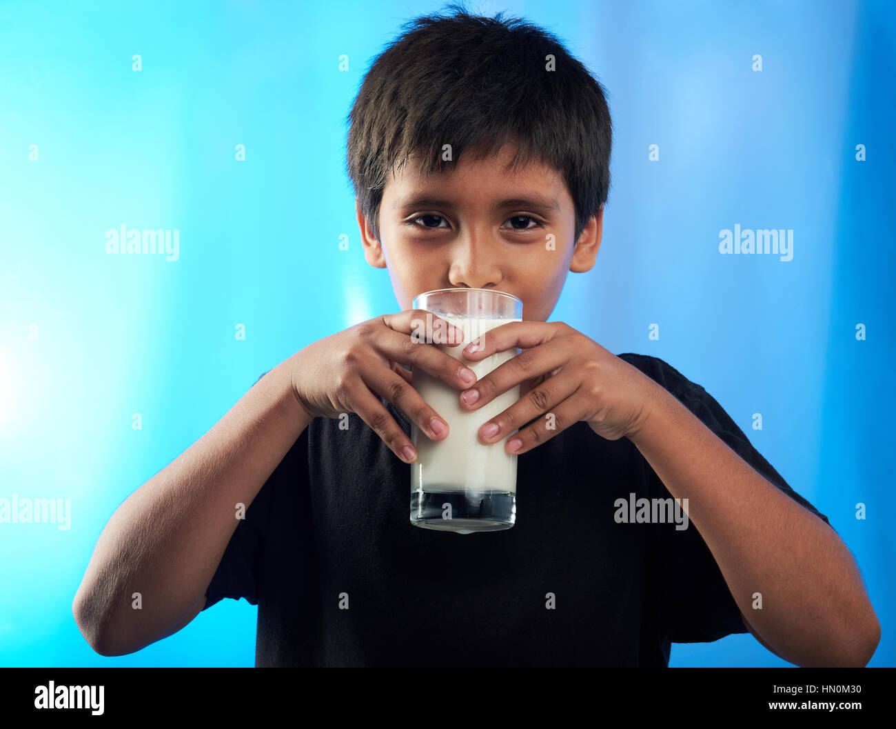 laino boy drink milk isolated on blue Stock Photo