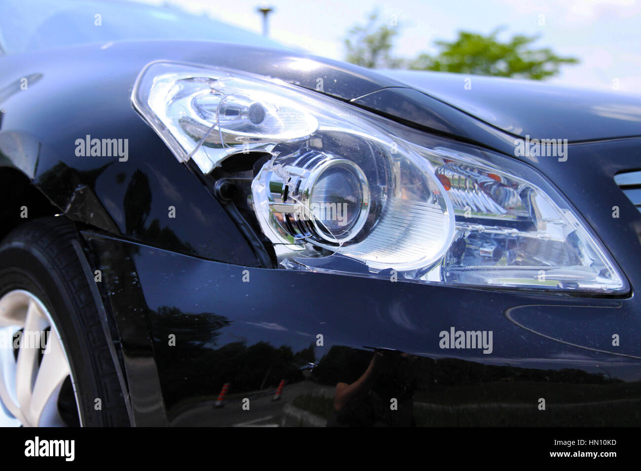 Headlight and body of a black car damaged in collision Stock Photo - Alamy