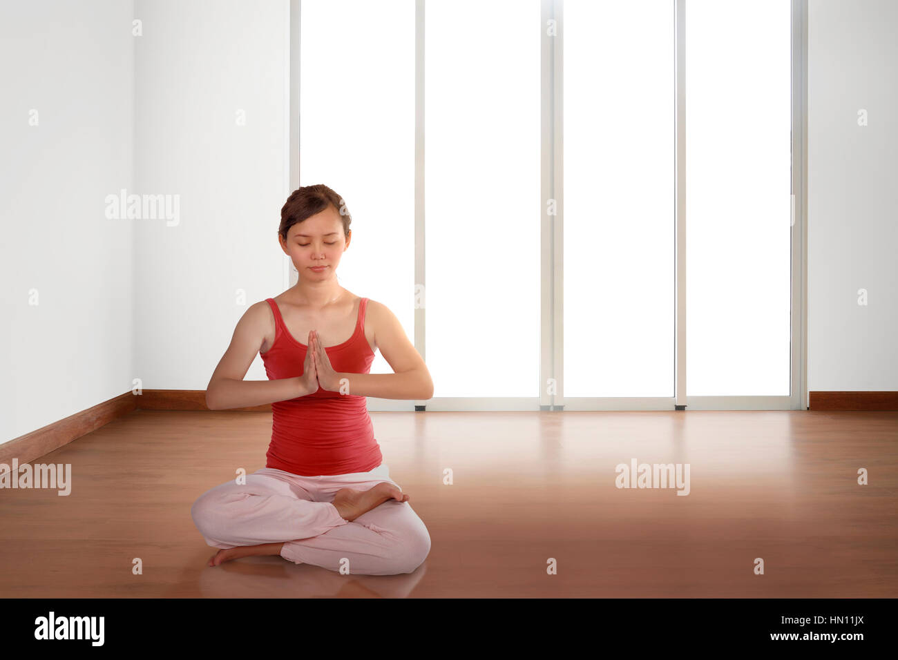 Young asian woman doing yoga in a lotus position at home Stock Photo ...