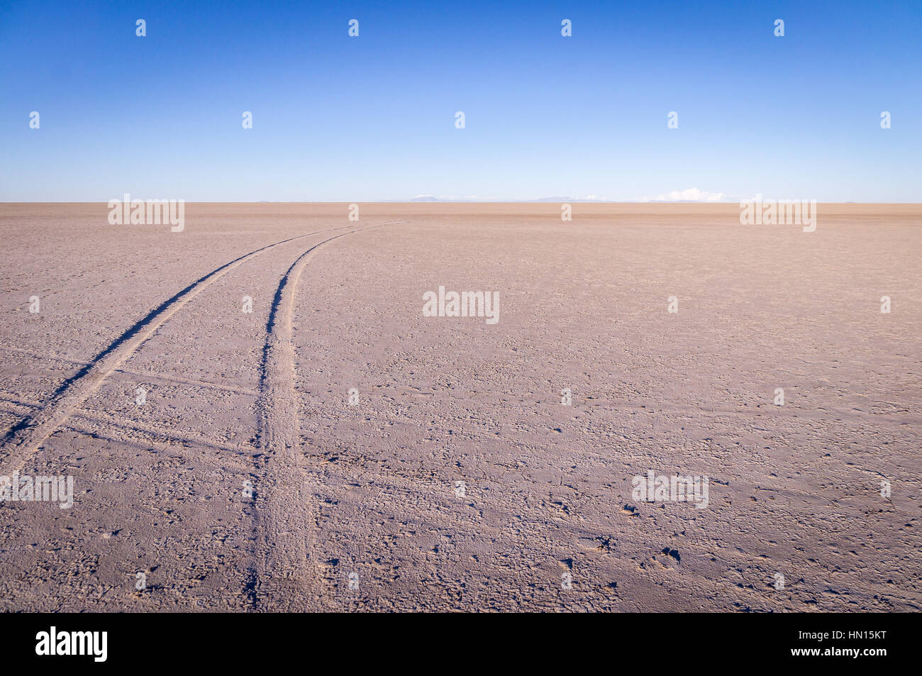 Car tracks on salt lake at Salar de Uyuni, Bolivia at sunrise Stock Photo