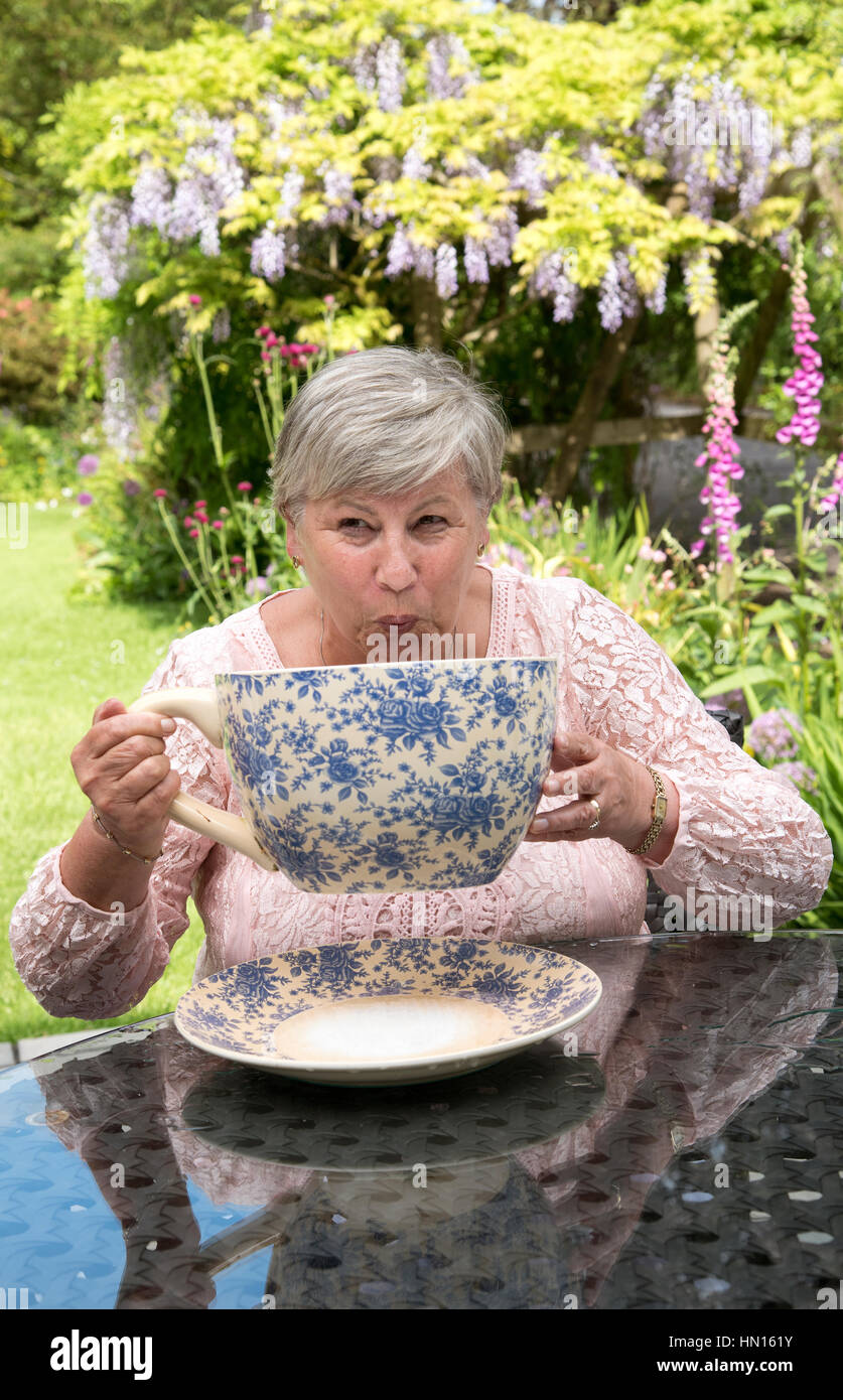 Woman drinking tea from a very large china cup in a Devonshire garden Stock  Photo - Alamy