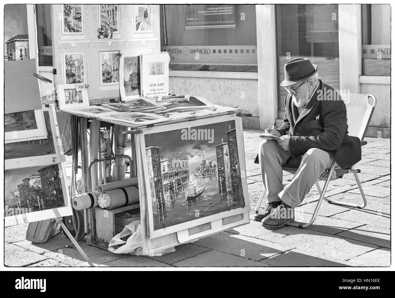 Artist with paintings for sale in monochrome at Venice, Italy in January Stock Photo