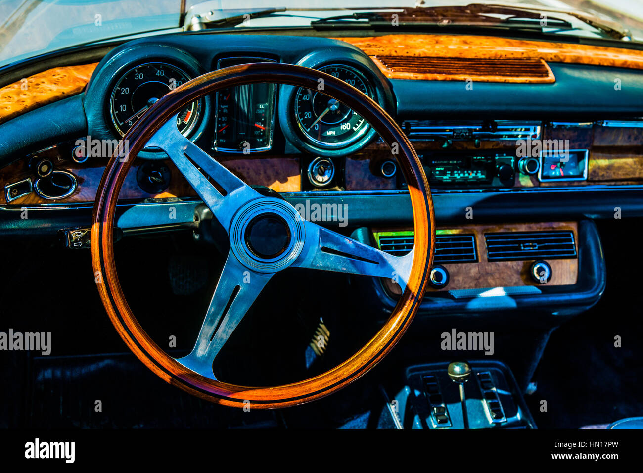 Color and beauty of vintage cars. Steering wheel and a dushboard of a vintage luxury European car. Orange and dark blue colors. Stock Photo