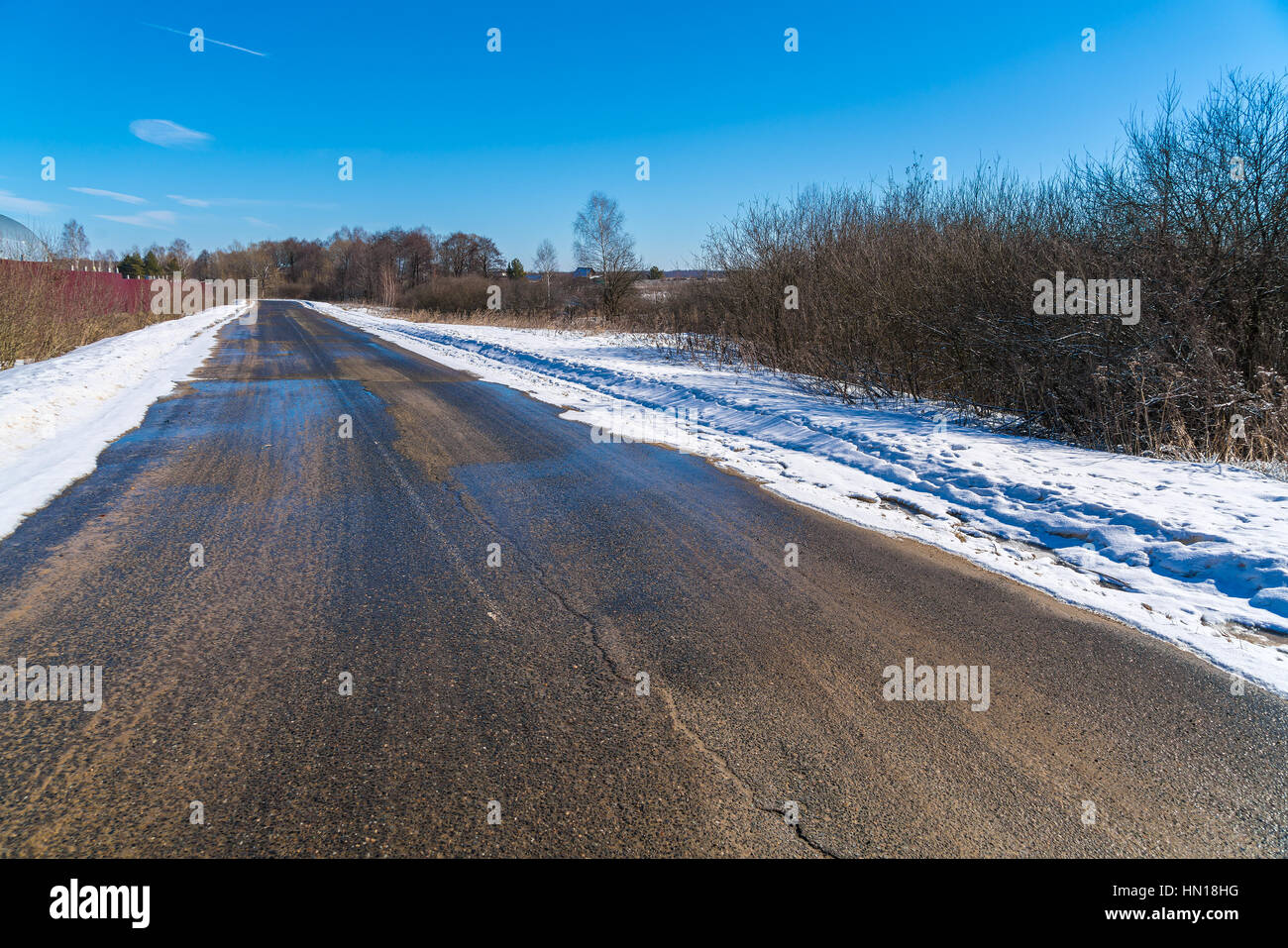 The road during the spring thaw with mud and puddles Stock Photo
