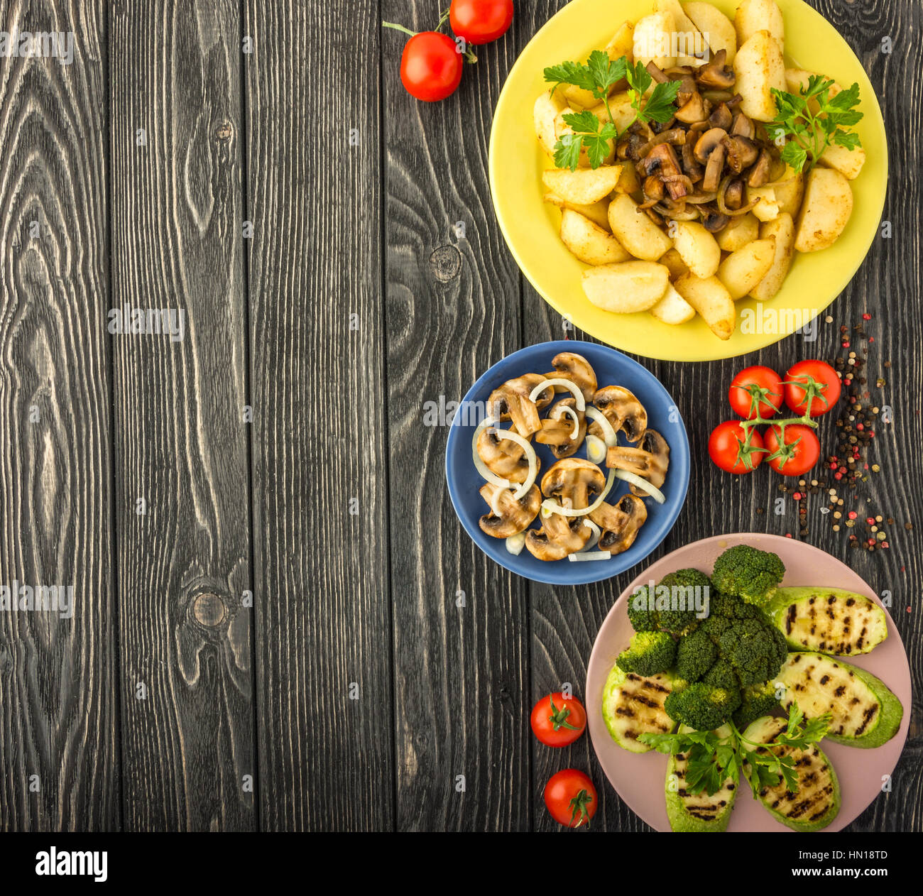 Diet vegetables grilled on a dark wooden table. Tasty, healthy, rich in vitamins and minerals: potatoes, mushrooms,tomato, broccoli, pepper, squash. T Stock Photo