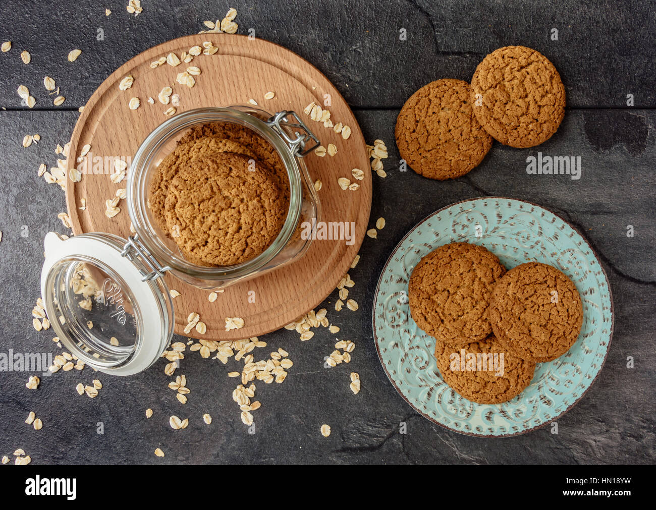 Oat cookies lay on a plate and bank with oatmeal cookies standing on a wooden board top view Stock Photo