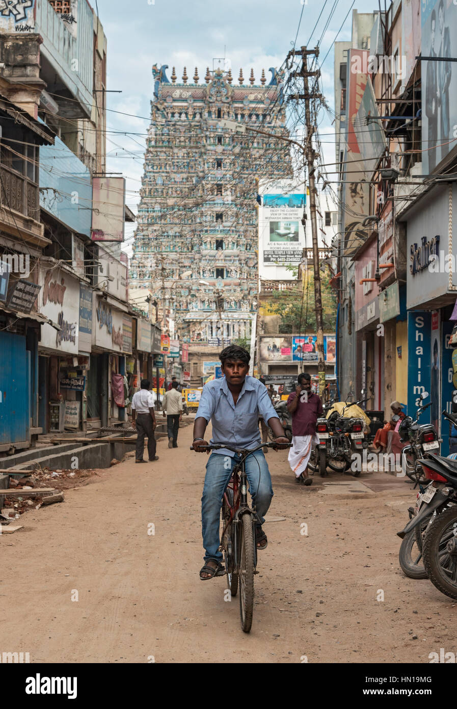 Cyclist in front of West Tower of Meenakshi Amman Temple, Madurai, Tamil Nadu, India Stock Photo