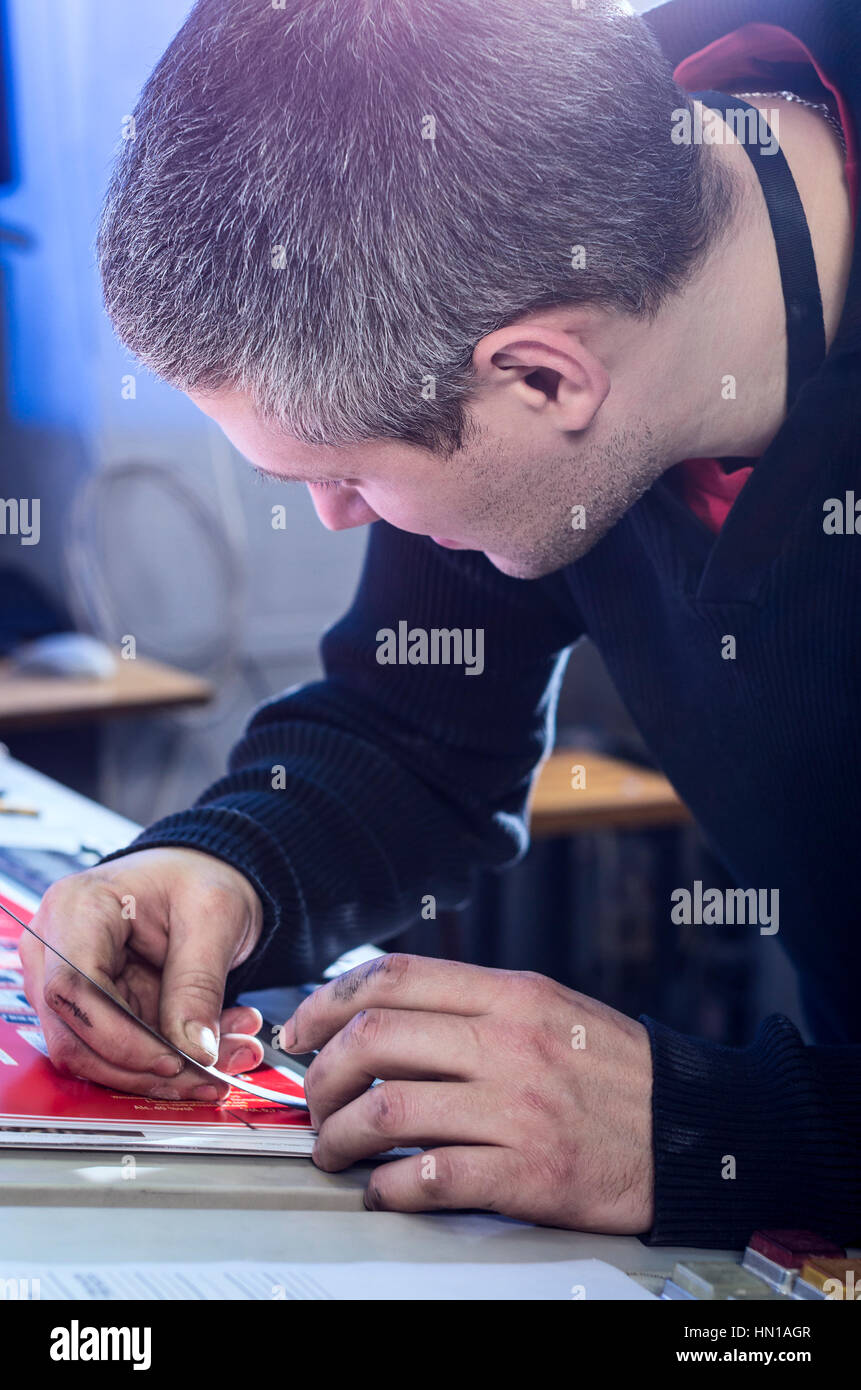 Young man in the process of offset printing and color correction Stock Photo