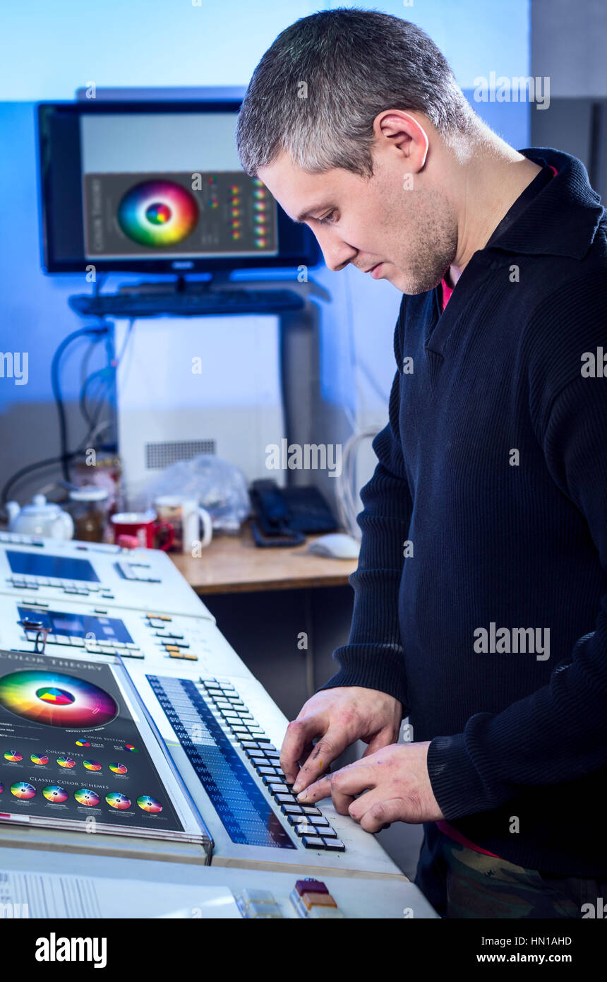 Young man in the process of offset printing and color correction Stock Photo