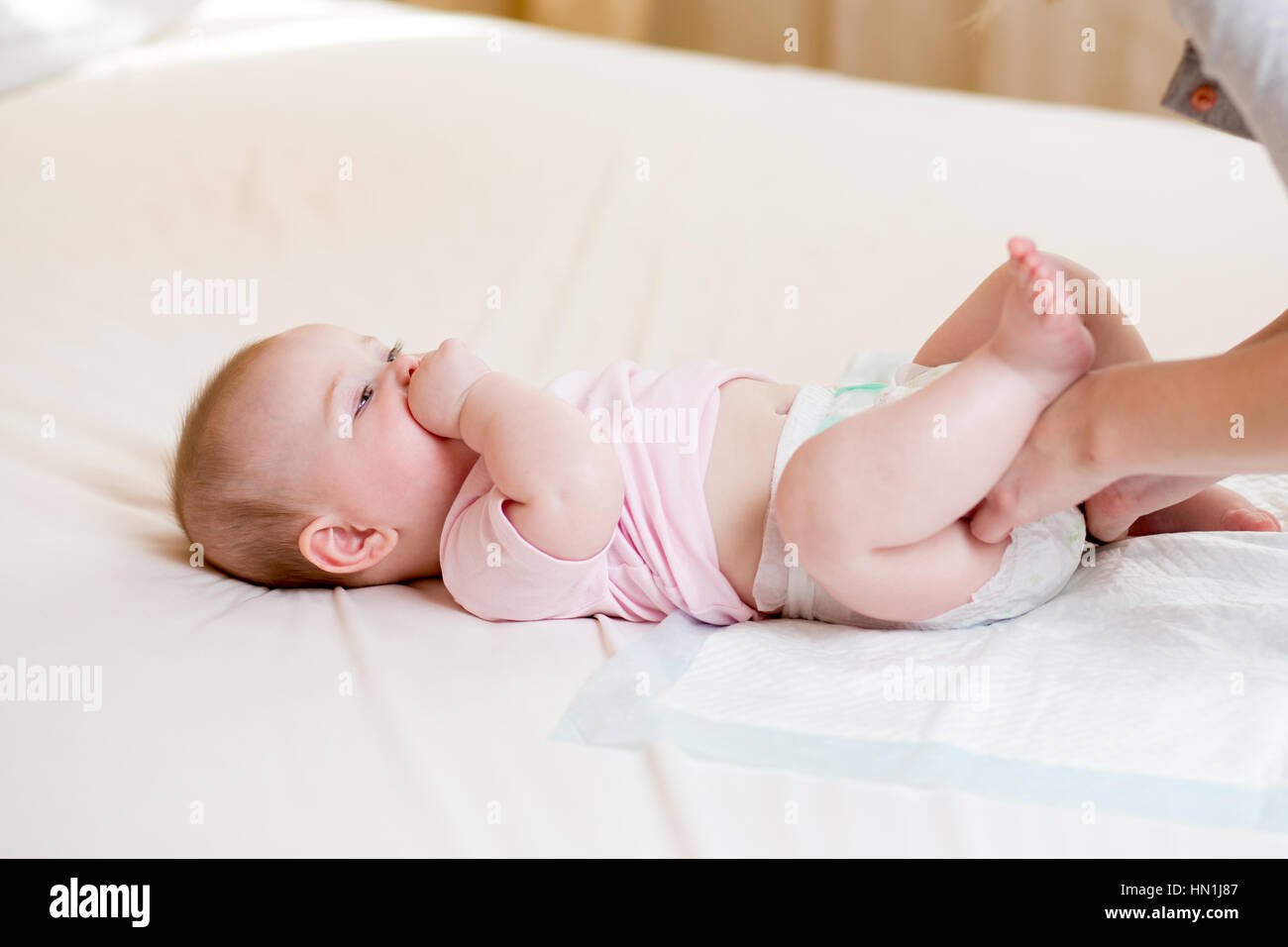 Mother taking care of little baby and changing diaper Stock Photo