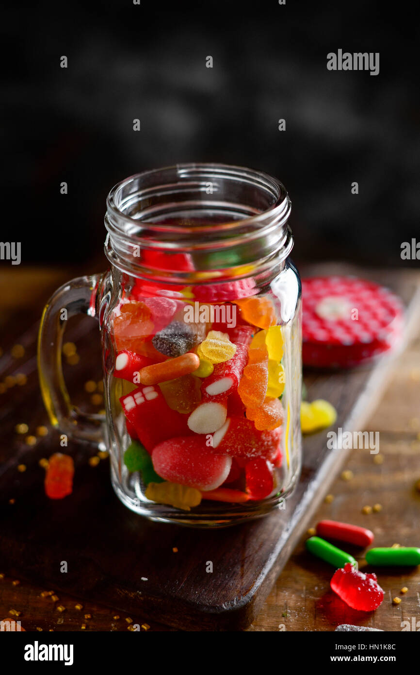 a mason jar full of candies with different flavors and colors, on a