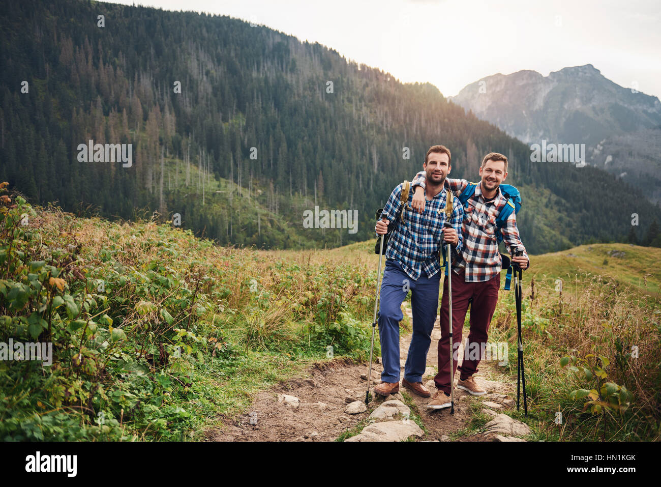 Smiling friends trekking together in the hills Stock Photo