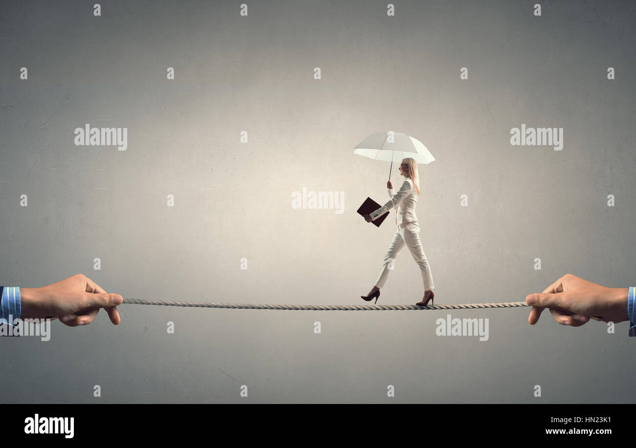 Elegant businesswoman with umbrella walking on strained rope Stock ...