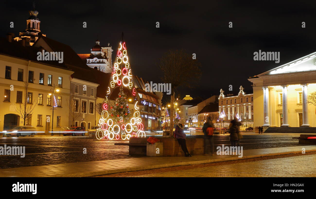 VILNIUS, LITHUANIA - JANUARY 2, 2017: A square in the Old town by night with the Town Hall on the right hand side and St Casimir's Church in the backg Stock Photo