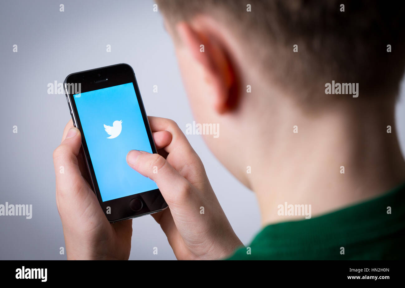 A teenage boy using Twitter on a mobile phone Stock Photo