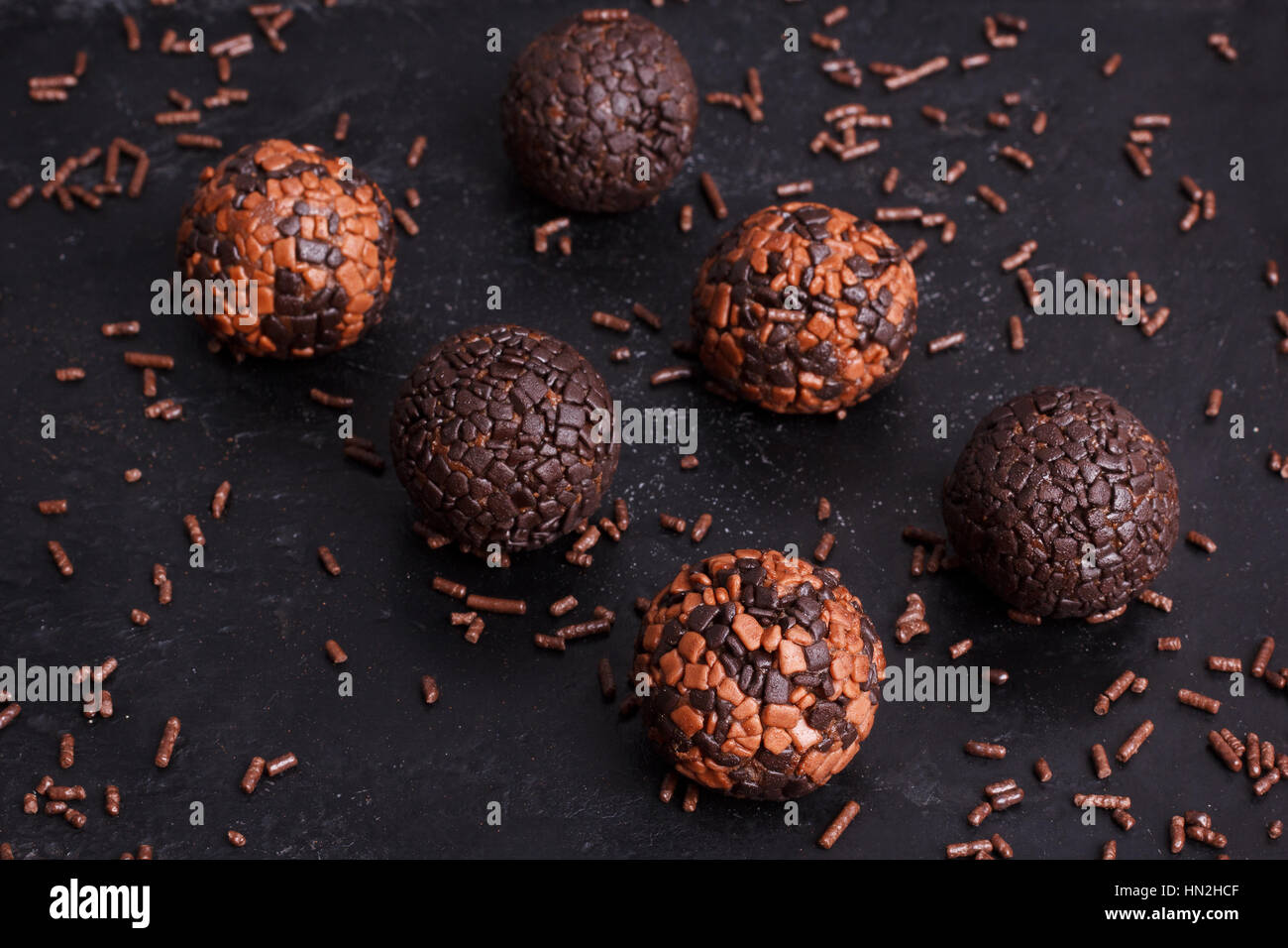 Brazilian chocolate truffle bonbon brigadeiro on black background. Selective focus Stock Photo