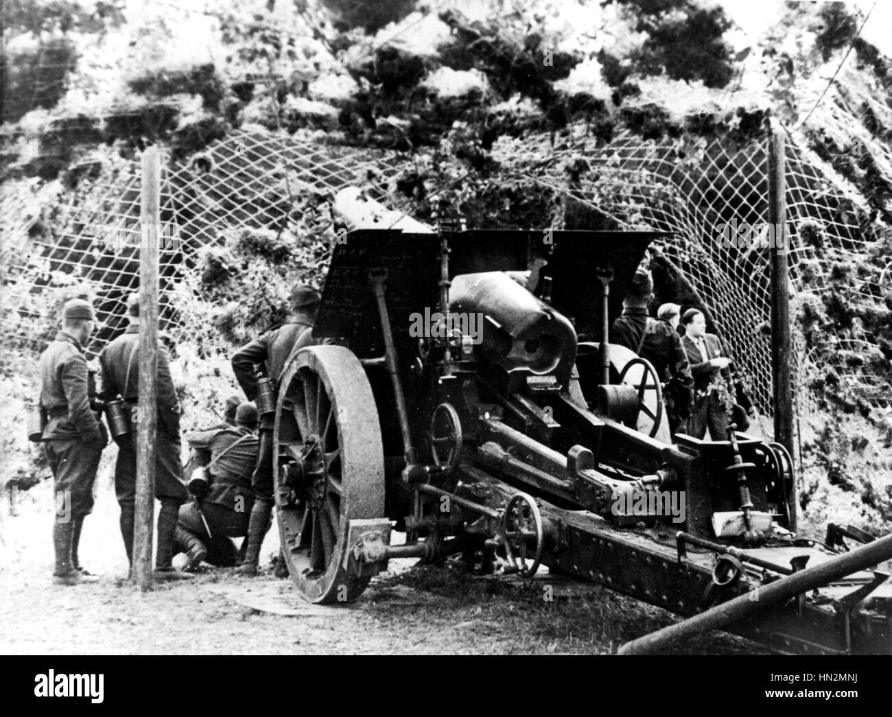 Military operations. 150 mm camouflaged cannon in action in the country September 1934 Czechoslovakia Paris. National Library Stock Photo