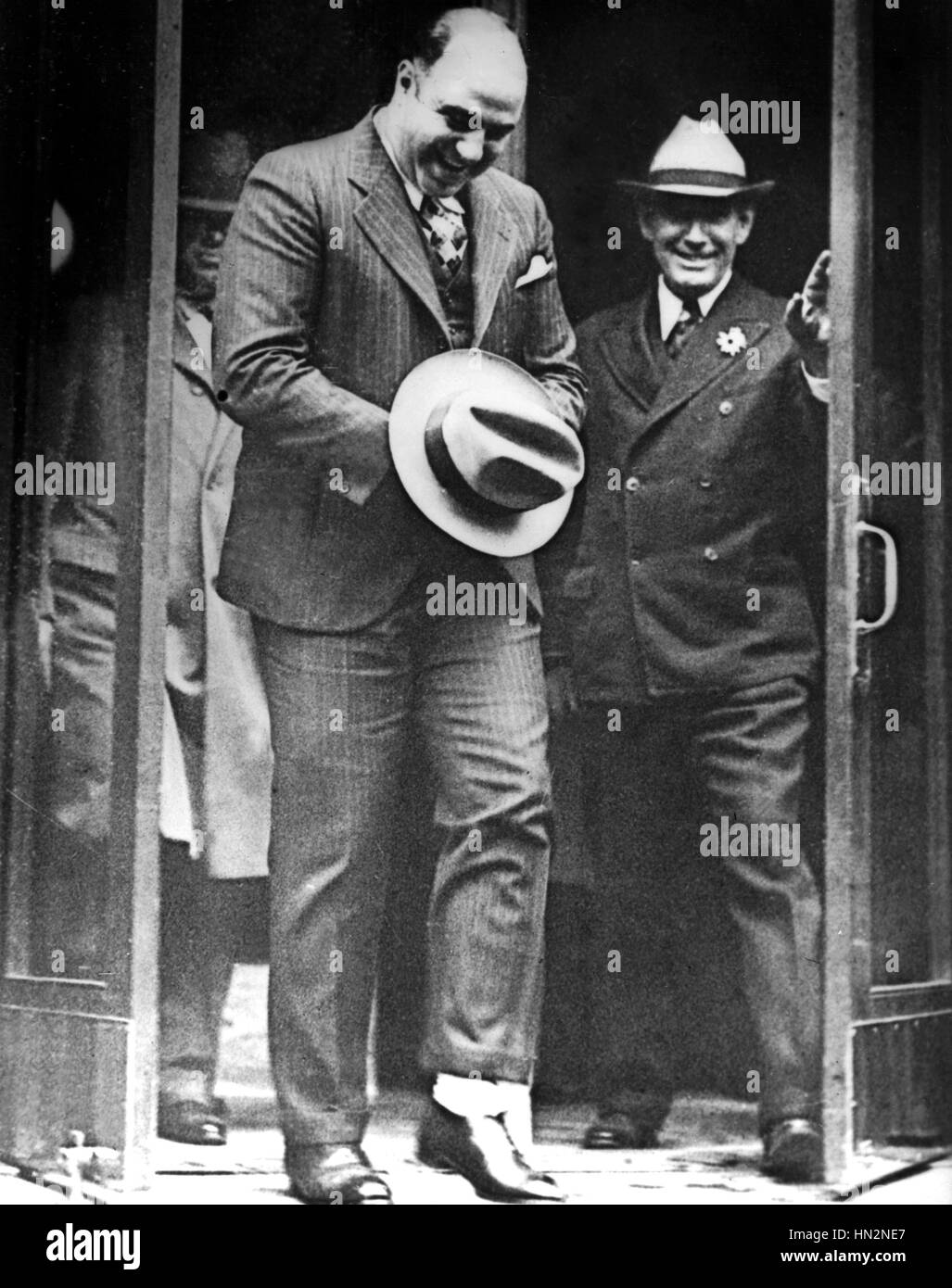 Al Capone, hiding handcuffs under his hat, is leaving the Atlanta Court after the hearing of his request for release. November 1932 United States National archives. Washington Stock Photo