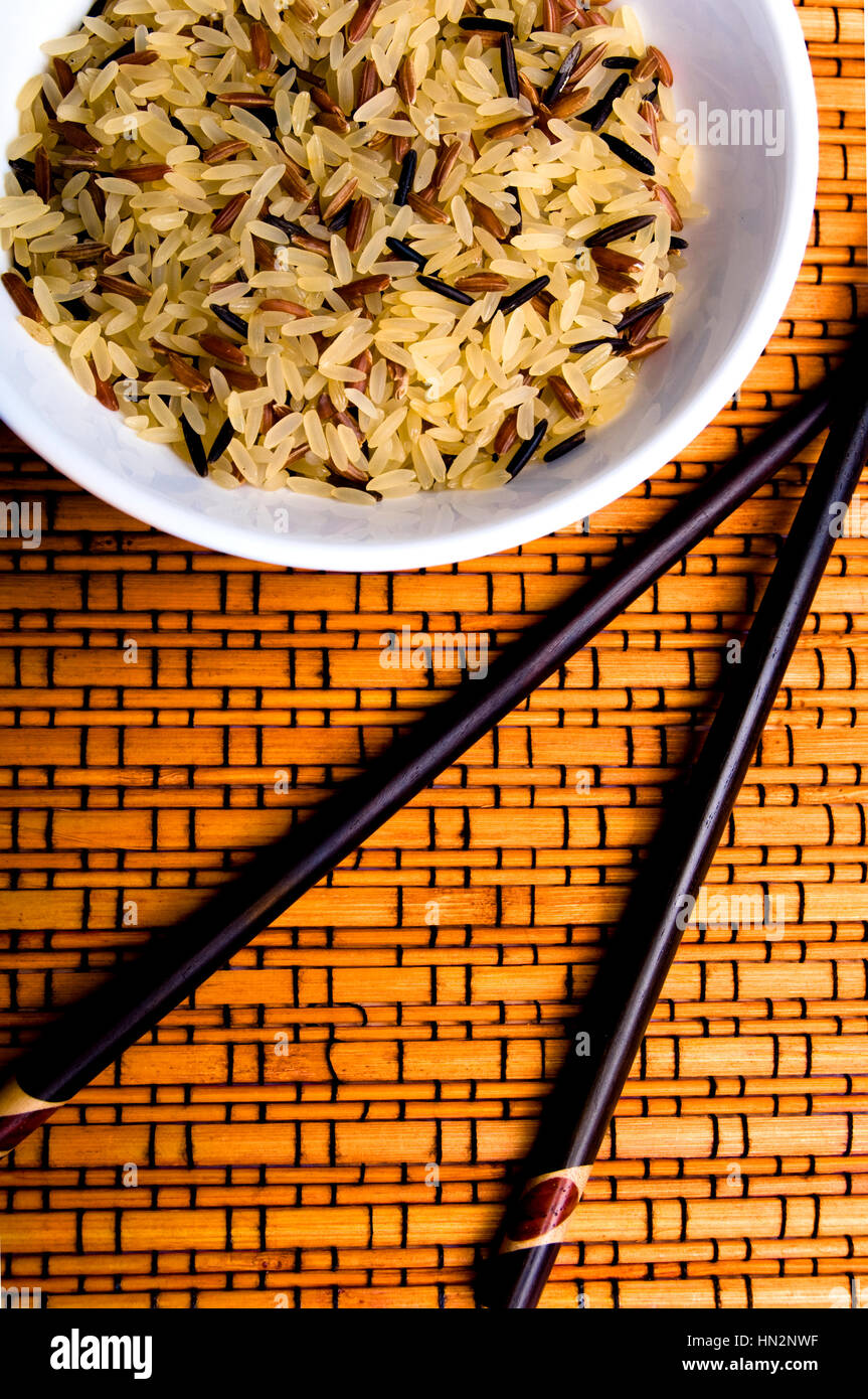 various kind of rice in a bowl, uncooked, and Chinese sticks Stock Photo