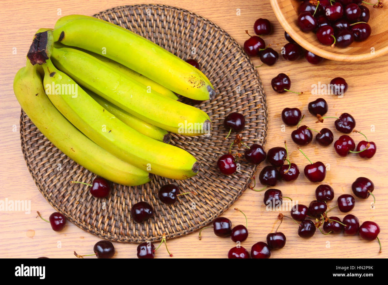 A Wooden Bowl of Mixed Fruits on a Wooden Background, Banana, Cherries, Peaches Stock Photo