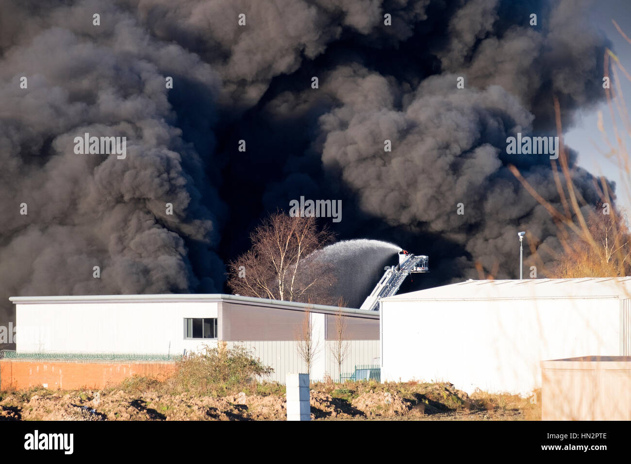 Large factory fire with plumes of thick black smoke Stock Photo