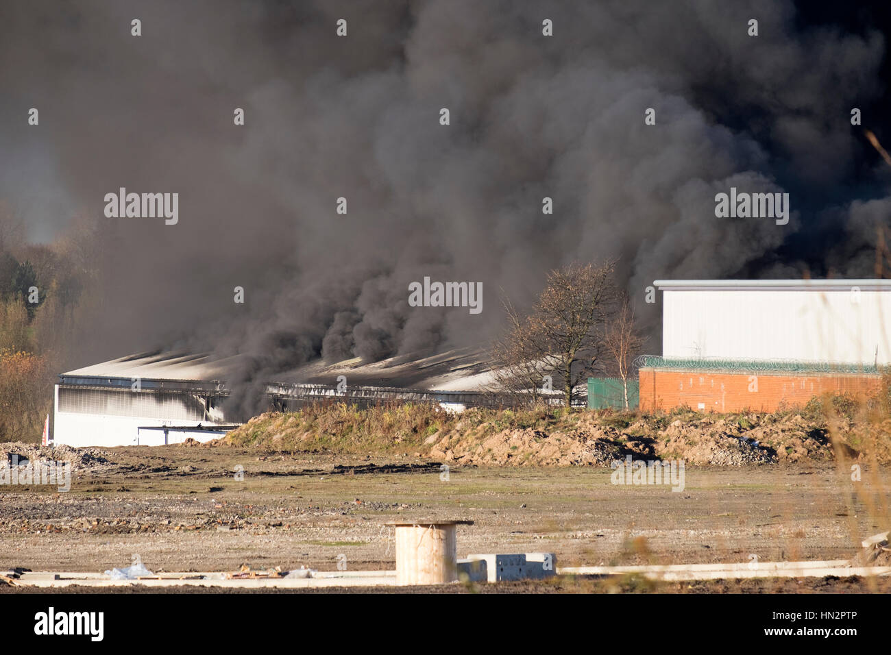 Large factory fire with plumes of thick black smoke Stock Photo