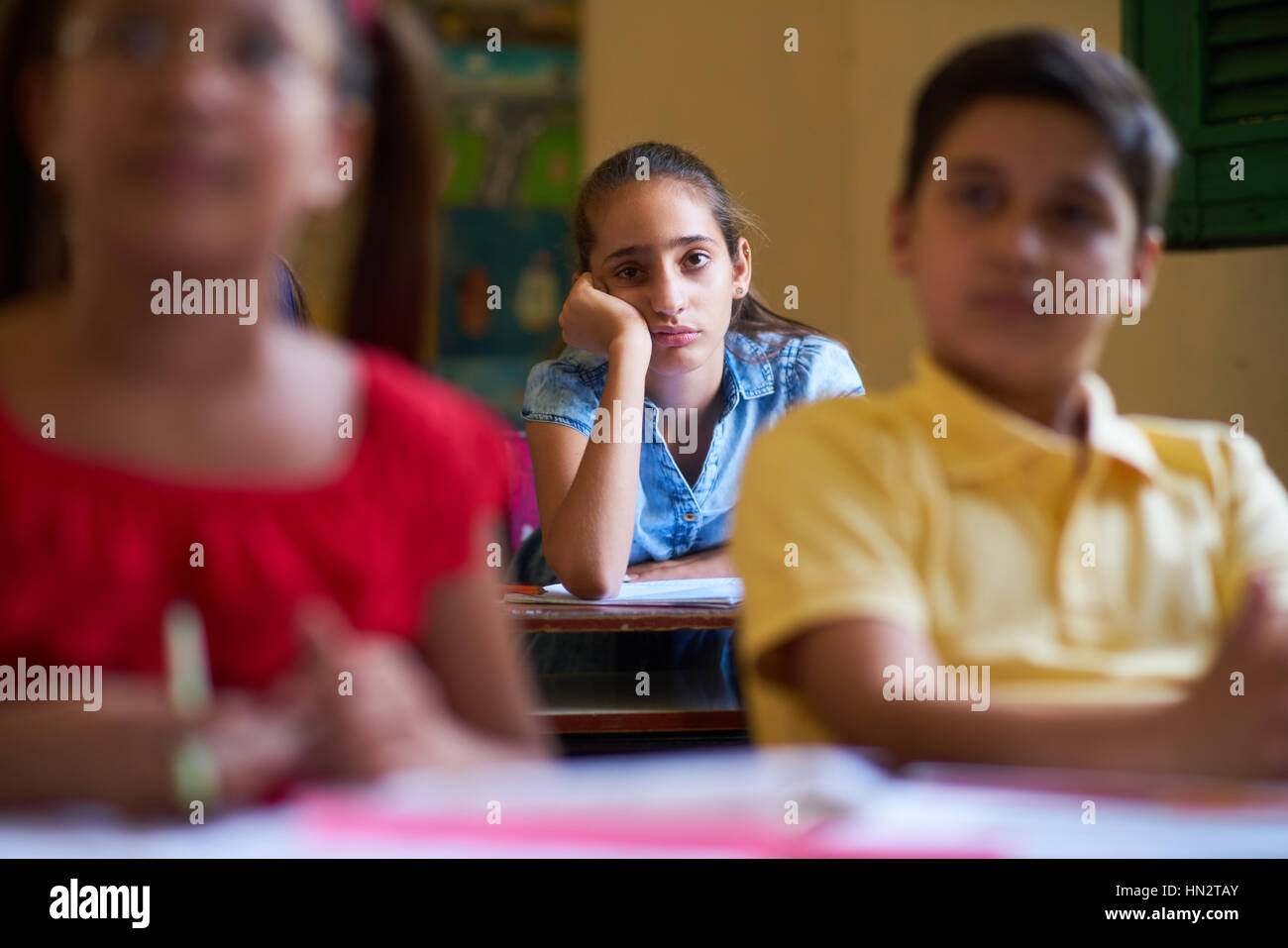 Young people and education. Group of hispanic students in class at school during lesson. Girl with anxiety, bored female student Stock Photo