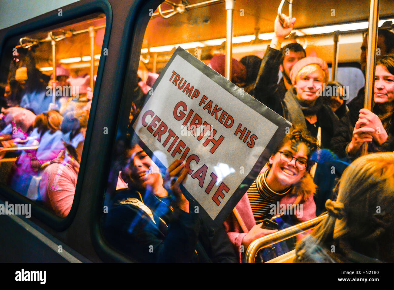 During the Women March On Washington, DC, a crowded Metro subway Car with man holding Anti-Trump Fake Girth sign on January 21, 2017 Stock Photo