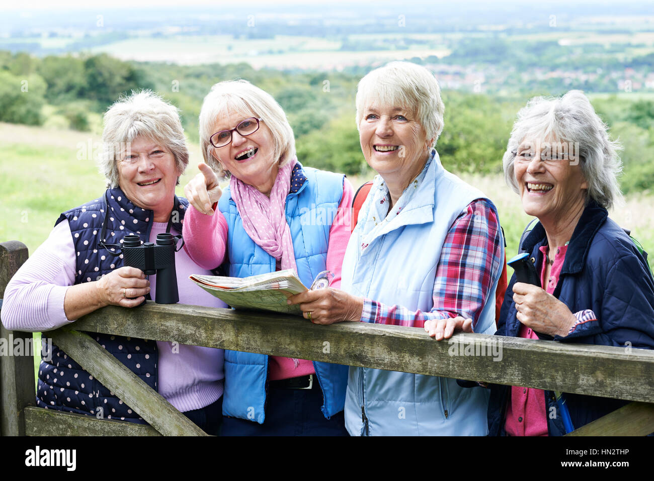 Group Of Senior Female Friends Hiking In Countryside Stock Photo