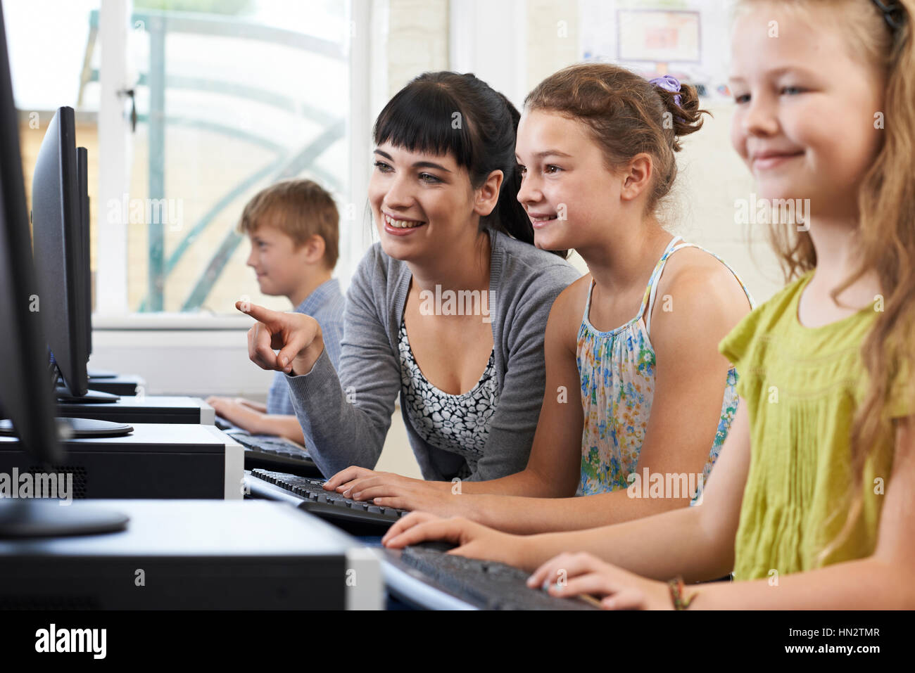 Female Elementary Pupil In Computer Class With Teacher Stock Photo - Alamy