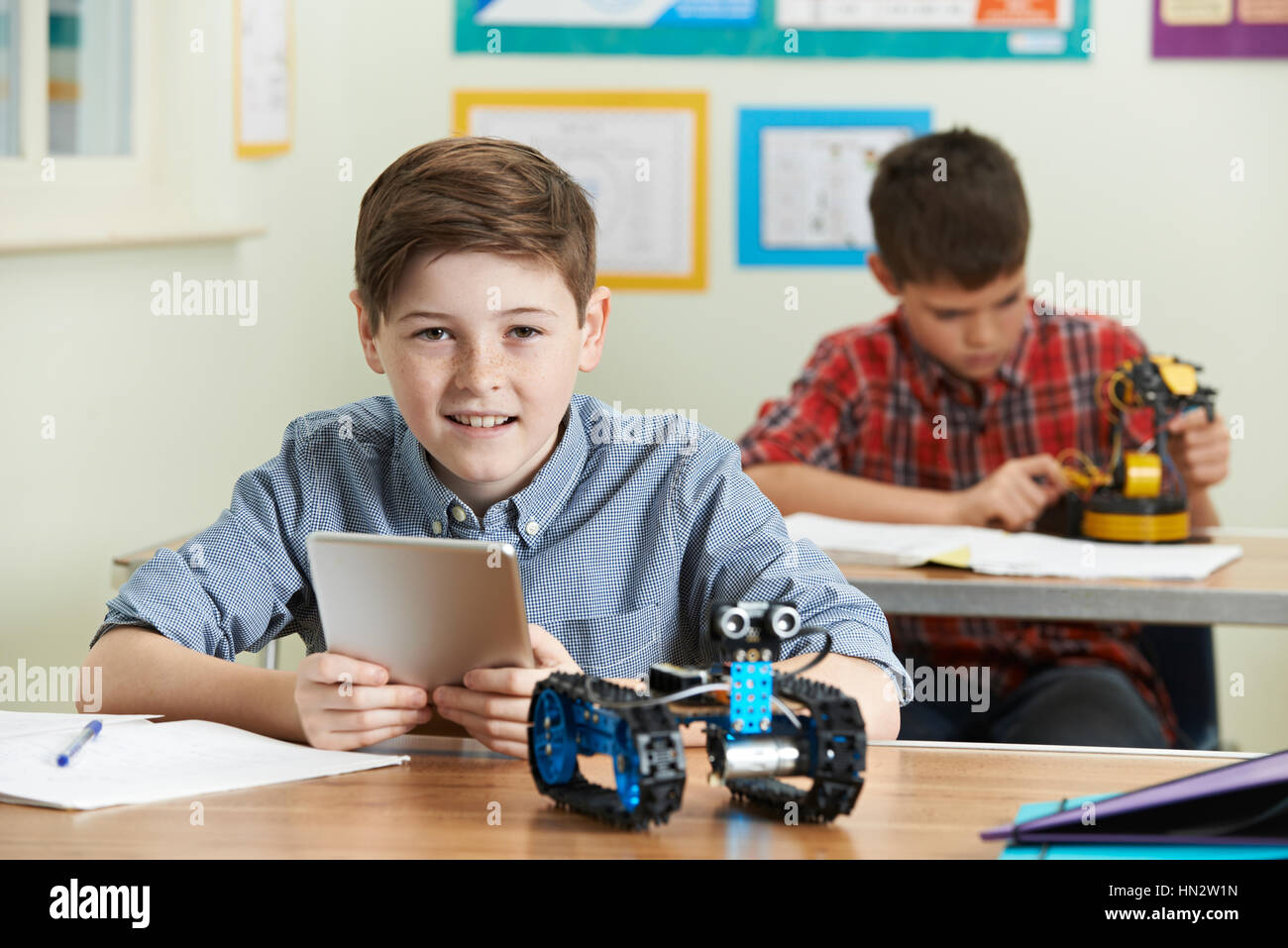 Pupil Controlling Robot With Digital Tablet In Science Lesson Stock Photo