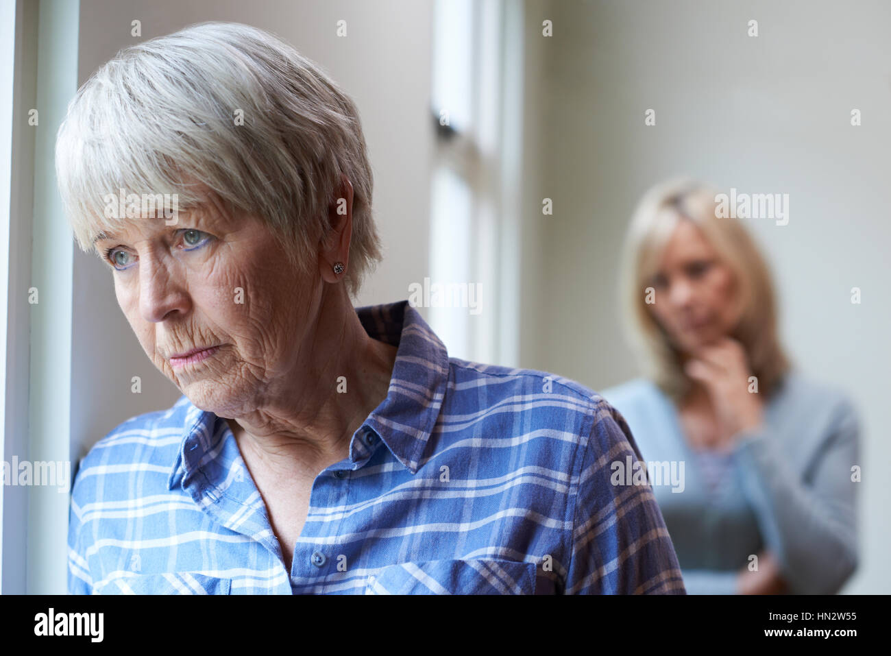 Serious Senior Woman With Adult Daughter At Home Stock Photo