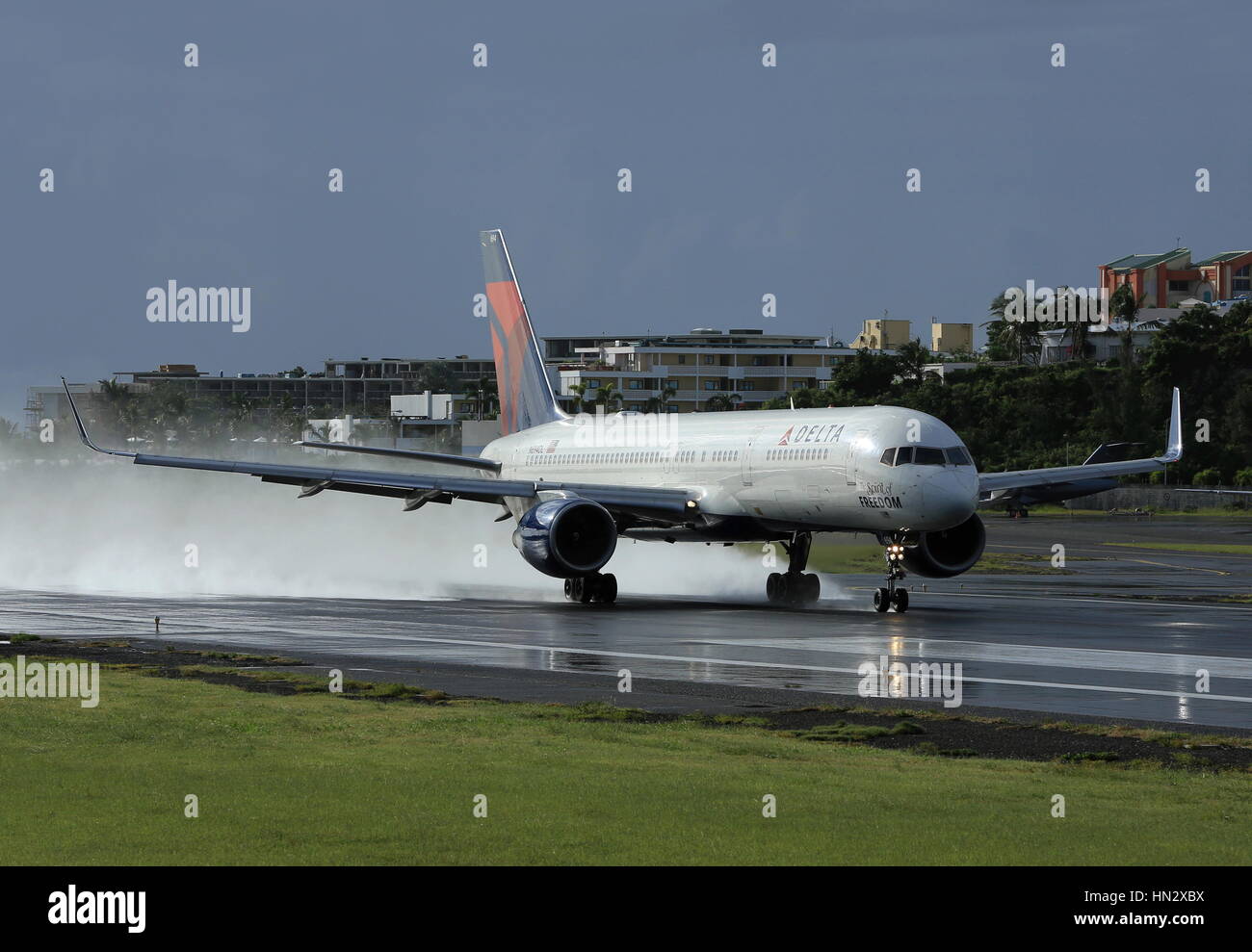 Delta Airlines Boeing 757 landing on a very wet runway at Sint Maarten (SXM) Stock Photo
