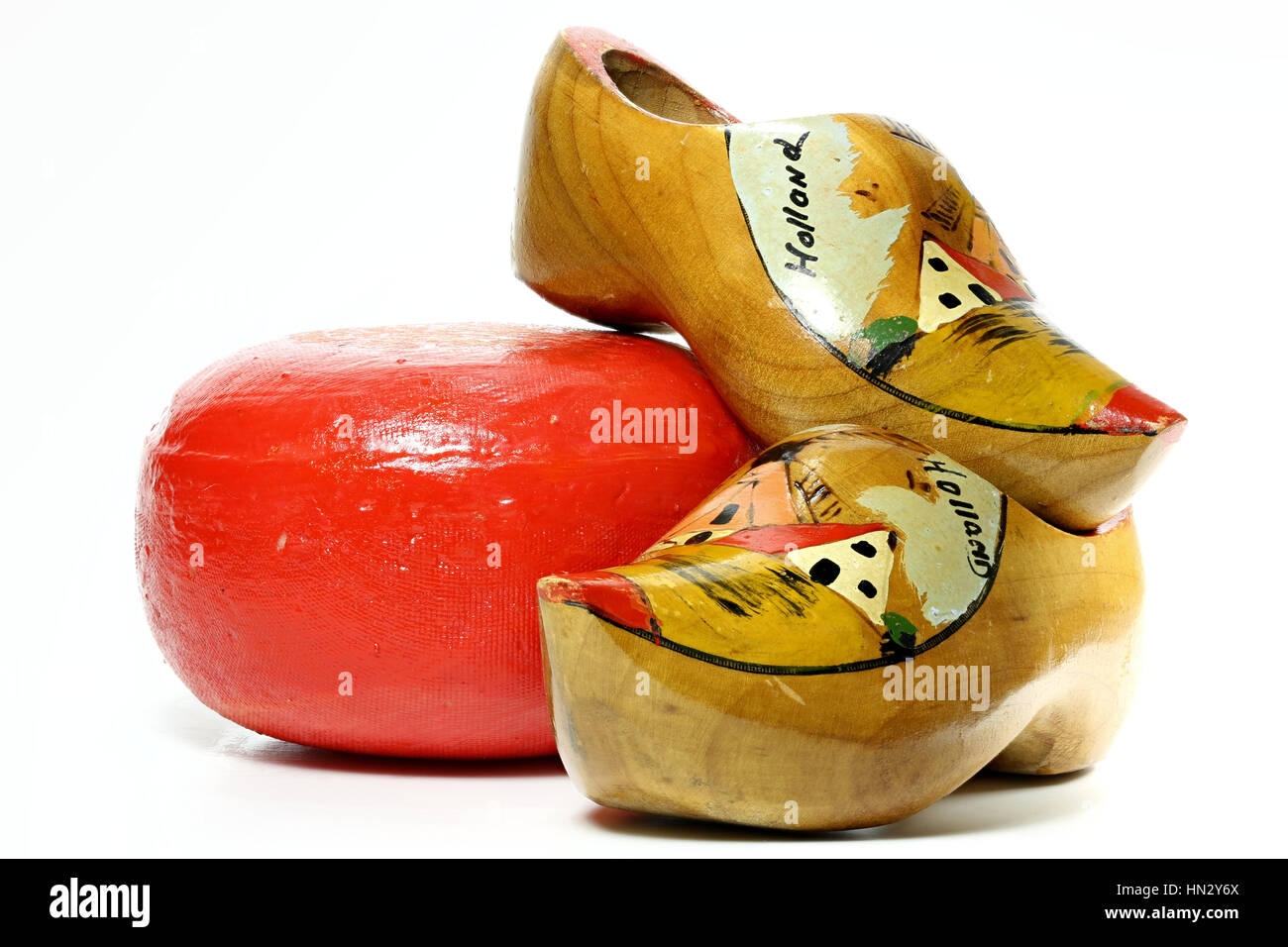 Edam cheese wheel with nostalgic Dutch souvenir clogs isolated on white background Stock Photo