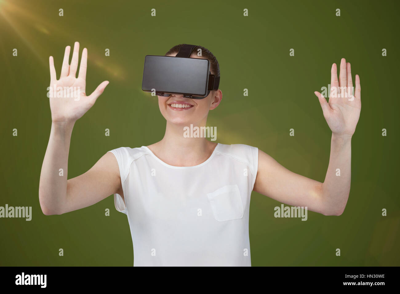 Happy woman gesturing while using virtual reality headset against green ...