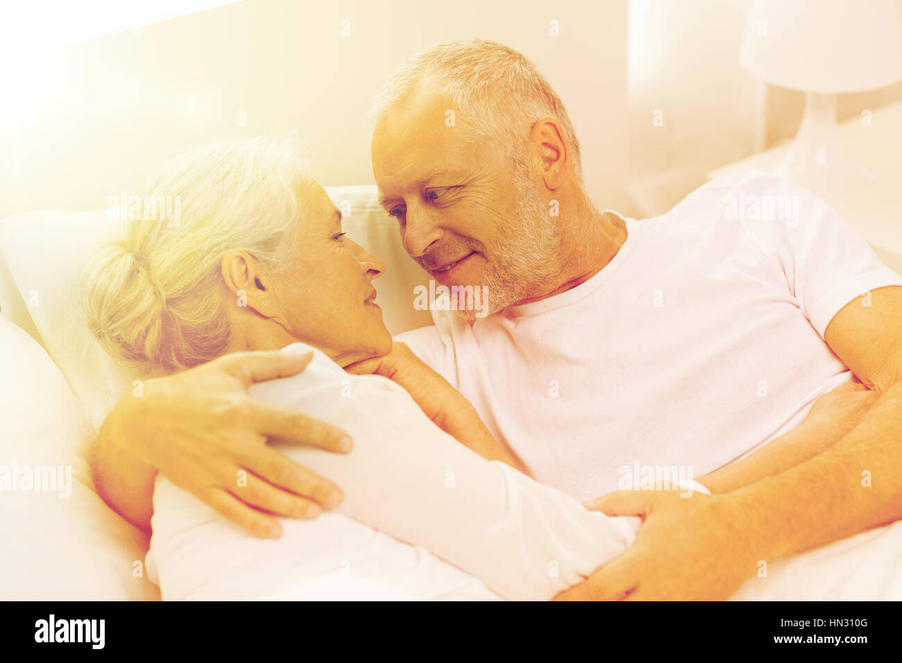 Old couple embracing in bed hi-res stock photography and images - Alamy