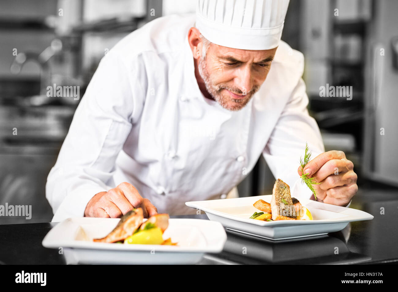Concentrated male chef garnishing food in kitchen Stock Photo Alamy