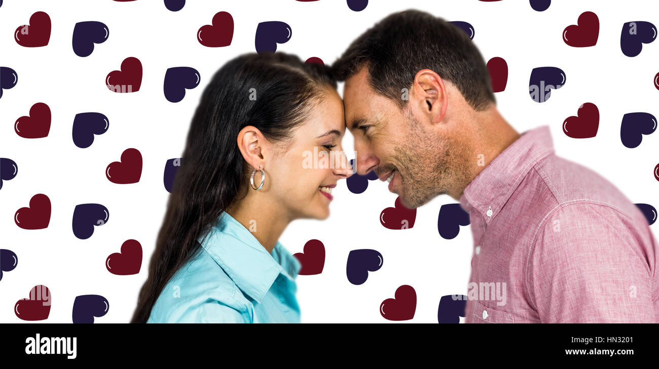 Smiling couple touching foreheads against background with hearts Stock Photo