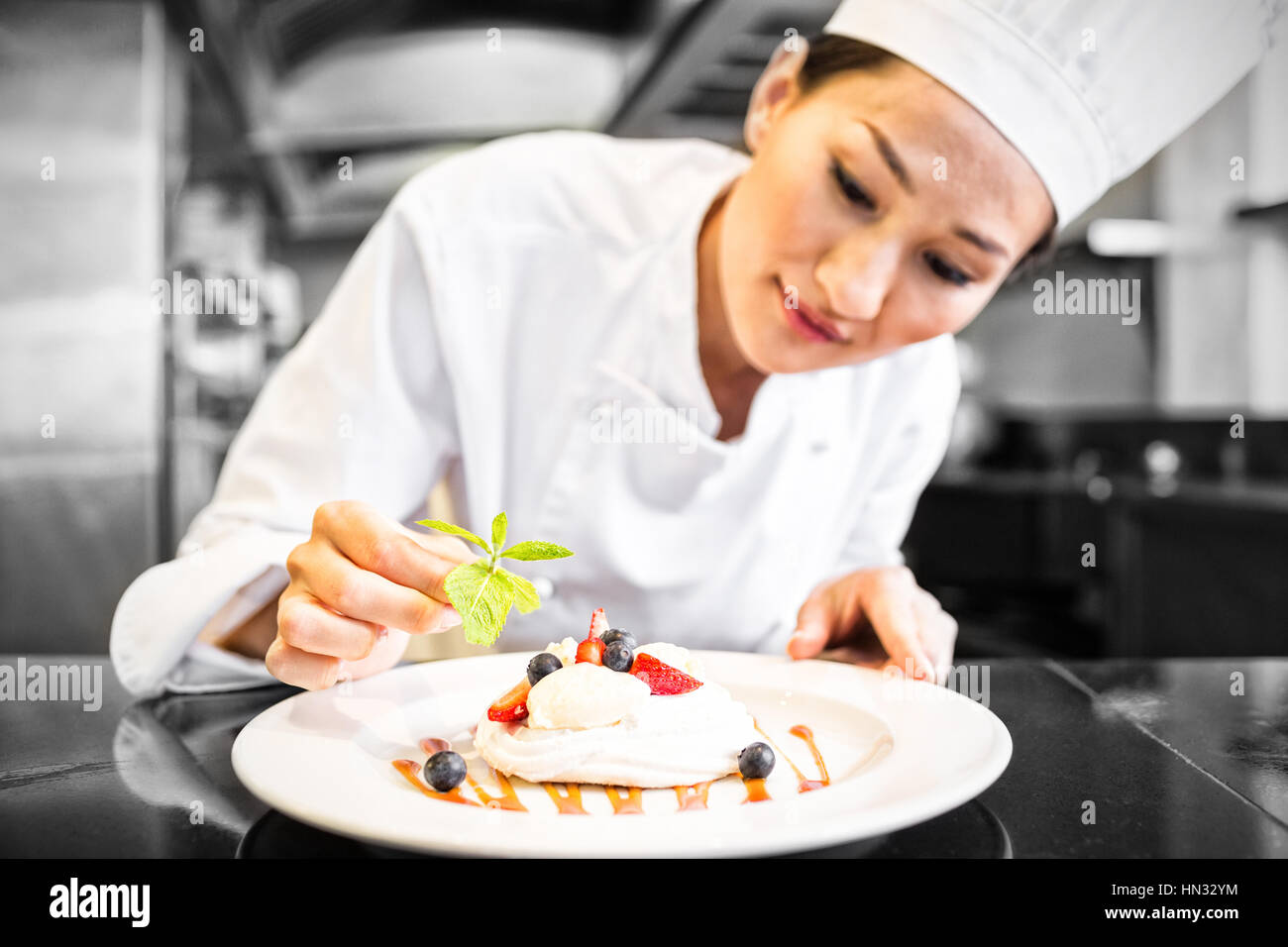 Concentrated female chef garnishing food in kitchen Stock Photo Alamy