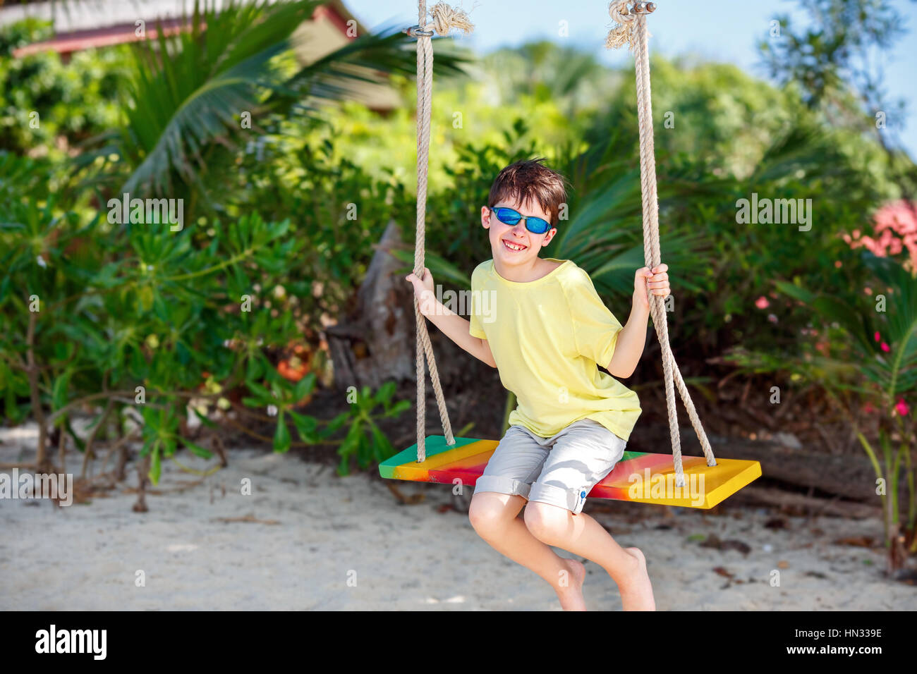 Cute boy having fun swinging at tropical island beach, Koh Samui island. Thailand, Asia Stock Photo