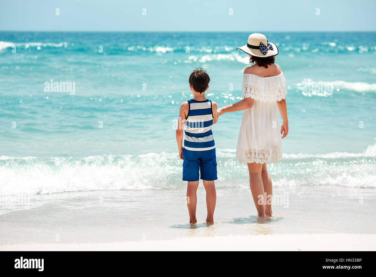 Back view of mother and son at Thai beach Stock Photo