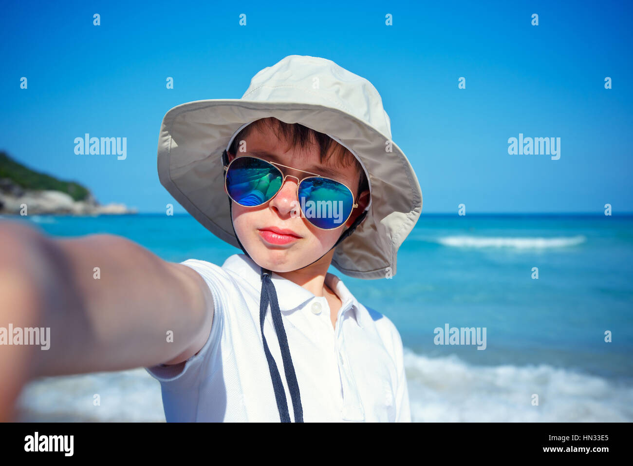 Cute little boy in sunglasses making selfie at tropical beach on exotic island Stock Photo