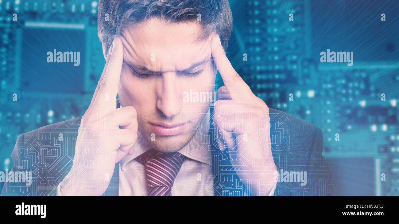Tensed businessman suffering from headache against shining blue circuit board Stock Photo