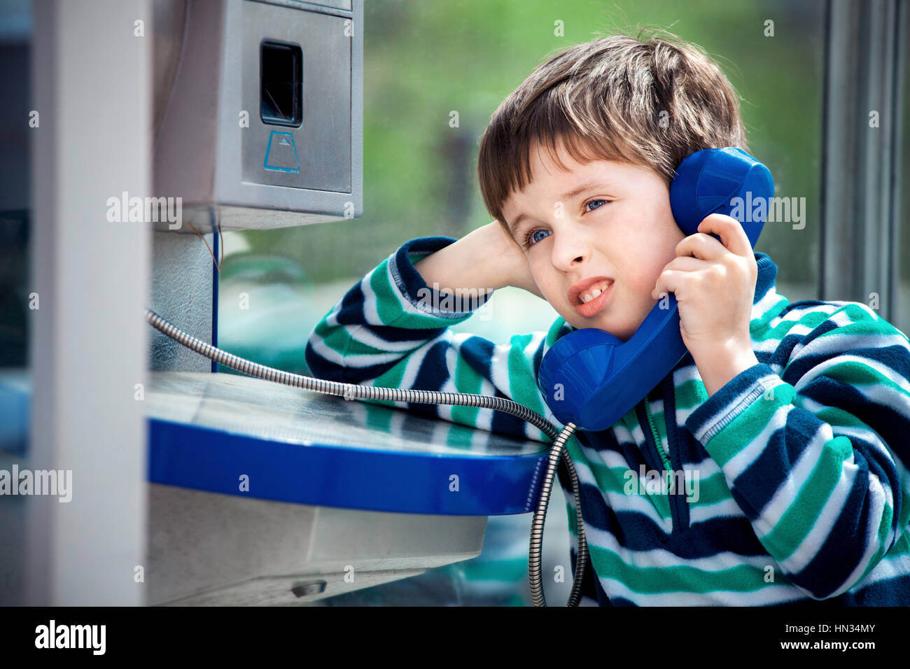 Включи телефон мальчик. Мальчик говорит по телефону. Мальчик звонит по телефону. Ребенок звонит. Ребенок в телефонной будке.