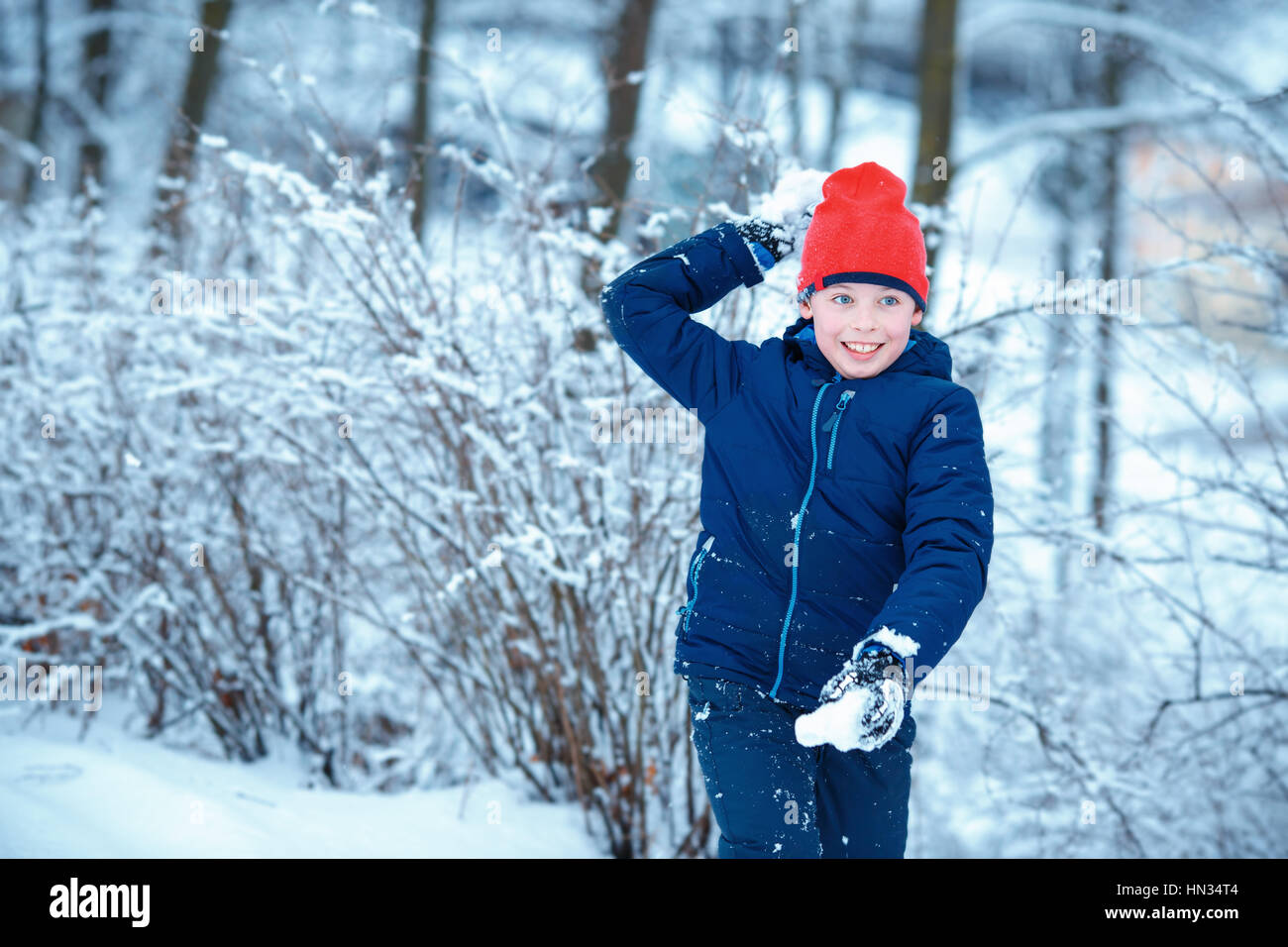 Cute little boy having fun with snowball fight winter Stock Photo
