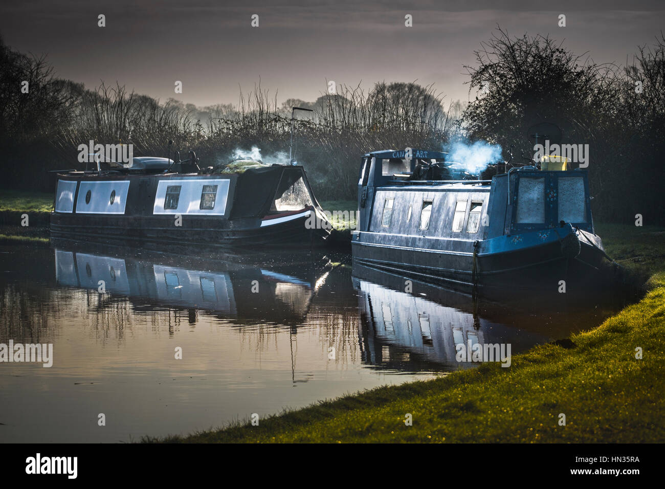 Two narrowboat homes at moorings on a canal. Stock Photo