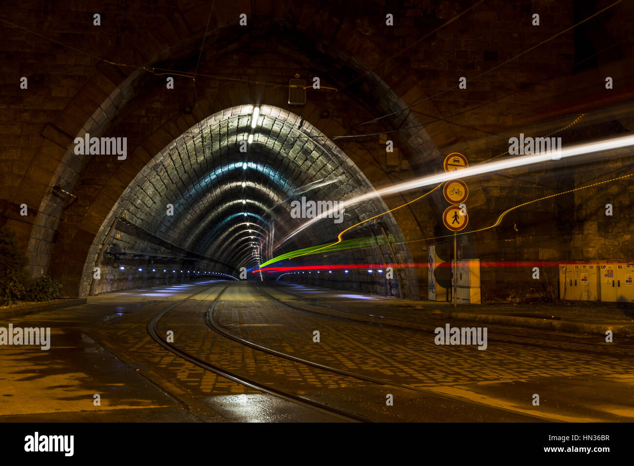 A tram travels into a tunnel in Bratislava at night. Stock Photo